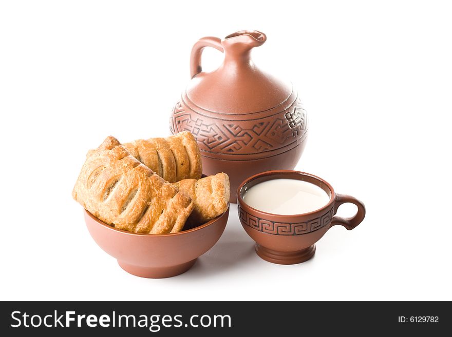 Appetizing pie, jug and cup of milk on a white background