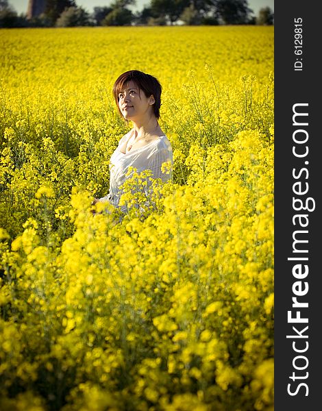 A girl in casual dress. taken in a field of rape. A girl in casual dress. taken in a field of rape.