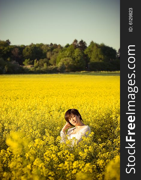 A girl in casual dress. taken in a field of rape. A girl in casual dress. taken in a field of rape.