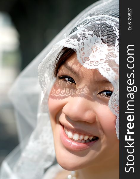 happy bride close up veil over face Portrait  asian  in white wedding wear. happy bride close up veil over face Portrait  asian  in white wedding wear