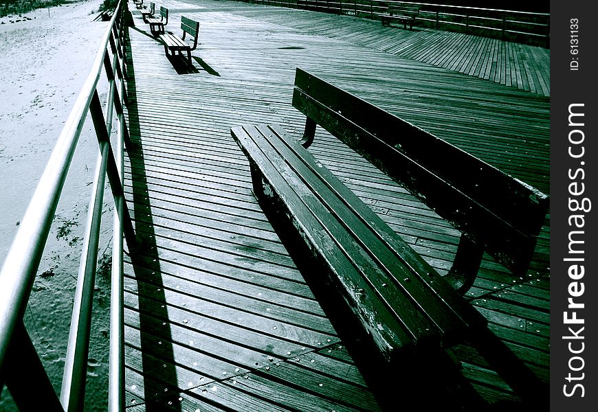 View of empty benches on the boardwalk just as sunset is about to kick in. View of empty benches on the boardwalk just as sunset is about to kick in