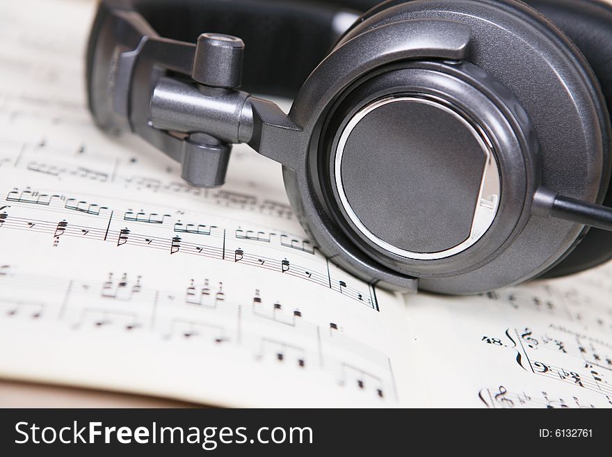 Headphone  on a book of score sheet. Headphone  on a book of score sheet