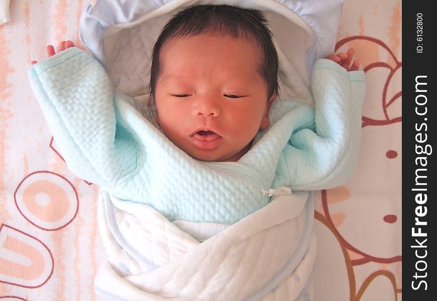 A Chinese baby on a bed. A Chinese baby on a bed