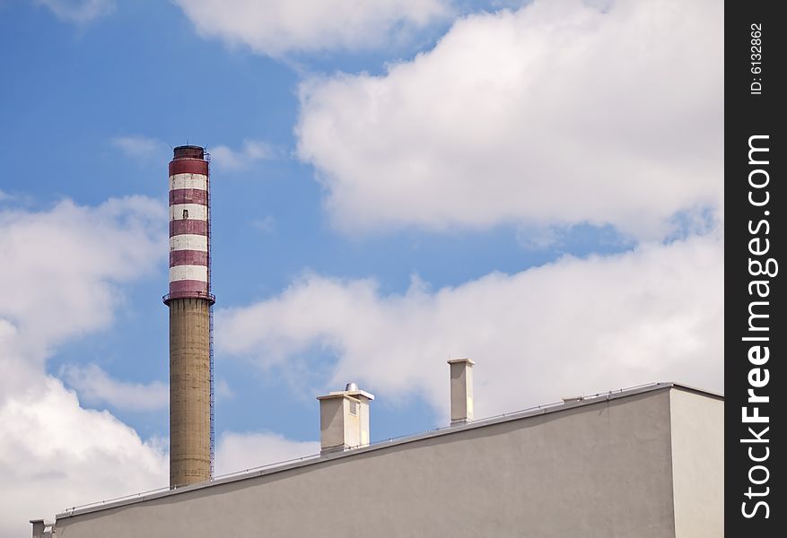 Big industrial chimney behind apartment building. Big industrial chimney behind apartment building