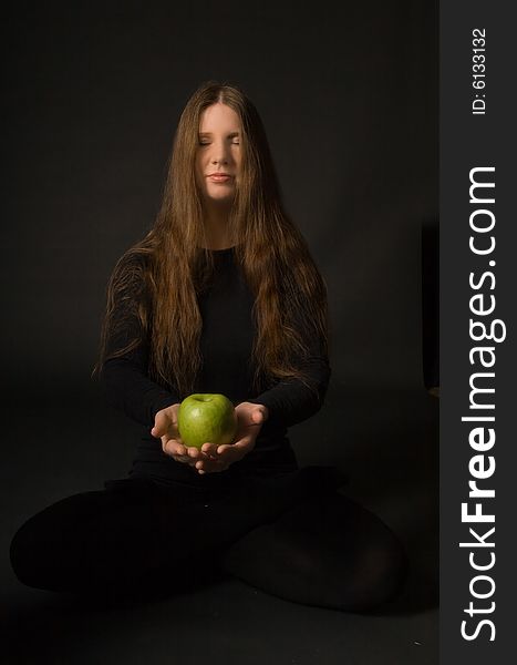 The portrait of a woman with a green apple in her hands. The portrait of a woman with a green apple in her hands