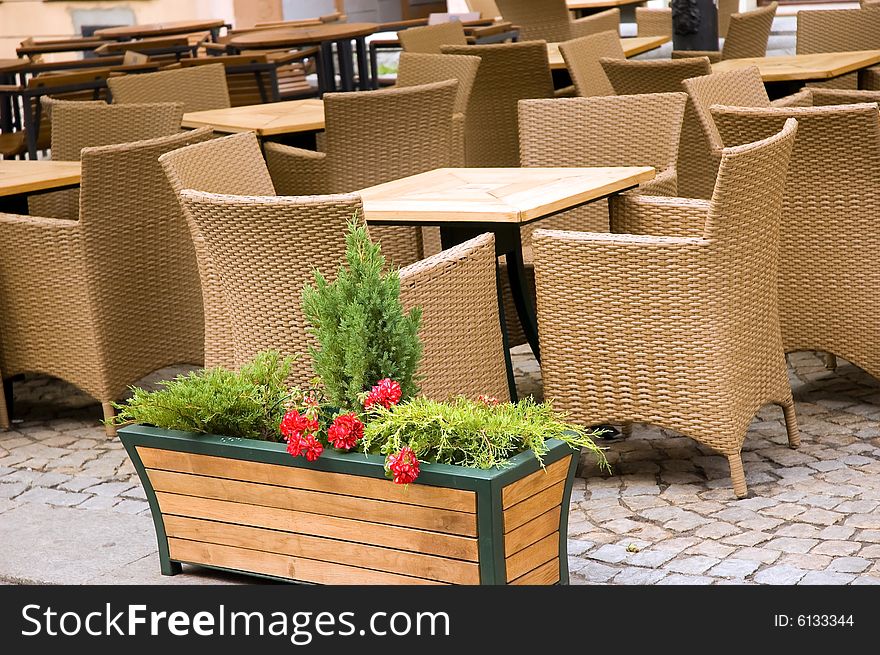Comfortable willow chairs and wooden tables outside a restaurant. Comfortable willow chairs and wooden tables outside a restaurant