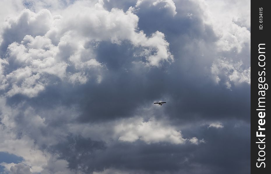 An airplane flying in the blue cloudy sky, horizontal image. An airplane flying in the blue cloudy sky, horizontal image