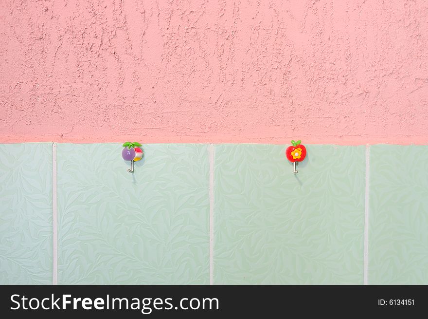 Pink stucco and green tiled wall. With hooks.
