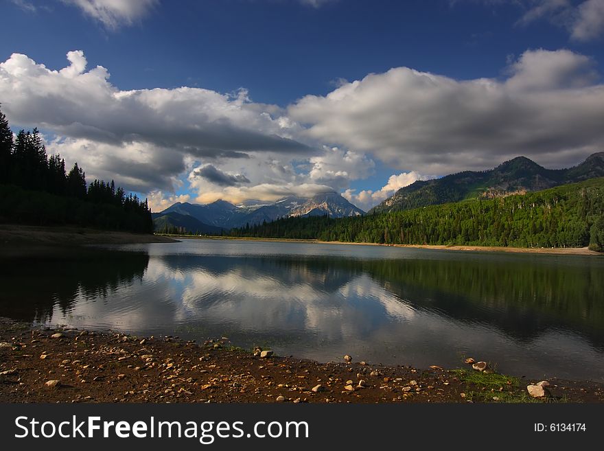 High Mountain Lake in the spring showing all the spring colors with mountains in the background