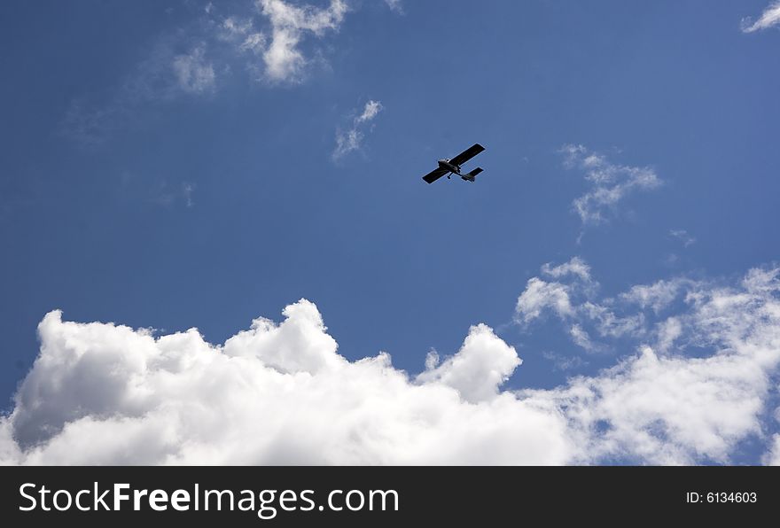 An airplane flying in the blue cloudy sky, horizontal image. An airplane flying in the blue cloudy sky, horizontal image