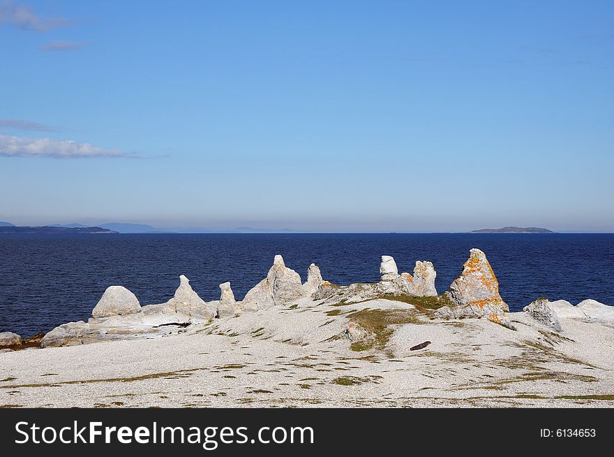 Rocks against deep blue sea and blue sky