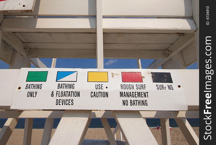 Lifeguard chair on beach with wide angle showing flag color meaning. Lifeguard chair on beach with wide angle showing flag color meaning