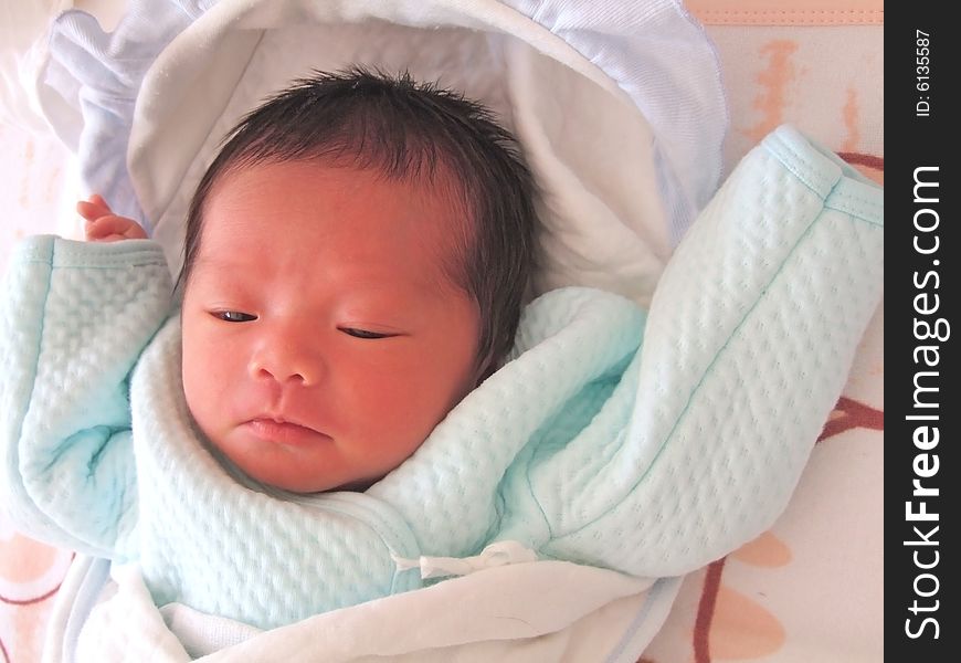 A Chinese baby on a bed. A Chinese baby on a bed