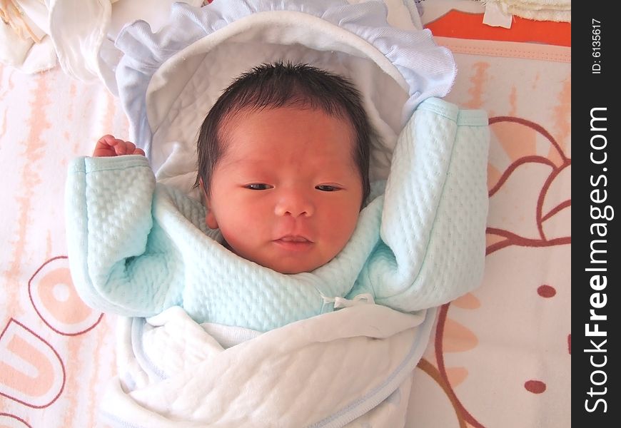 A Chinese baby on a bed. A Chinese baby on a bed