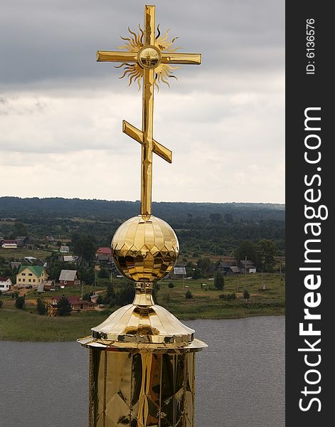 Gold cross with belltower's reflection on orthodox church in a monastery of Nil Stolbenskij, Island Stolbnyj, lake Seliger, near Ostashkov, Russia, view from a belltower