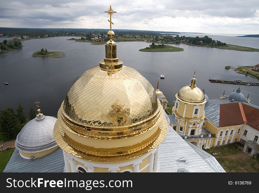 Gold domes of orthodox church in a monastery of Nil Stolbenskij, Island Stolbnyj, lake Seliger, near Ostashkov, Russia, view from a belltower. Gold domes of orthodox church in a monastery of Nil Stolbenskij, Island Stolbnyj, lake Seliger, near Ostashkov, Russia, view from a belltower