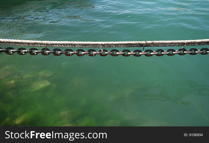 Mooring a chain and a rope hanging over water. Mooring a chain and a rope hanging over water