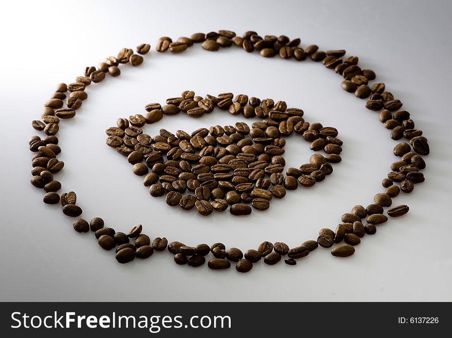 Coffee beans cup shape made with fresh roasted coffee beans light up with spot light and beautiful DOF.