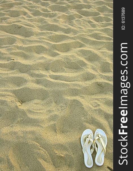 Couple slippers in sand close up