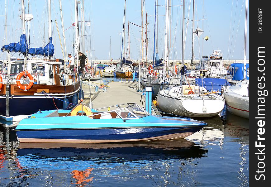 Old blue motor boat moored in the yacht port. Old blue motor boat moored in the yacht port.