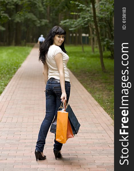 Young smiling brunet girl with shopping bags outdoor