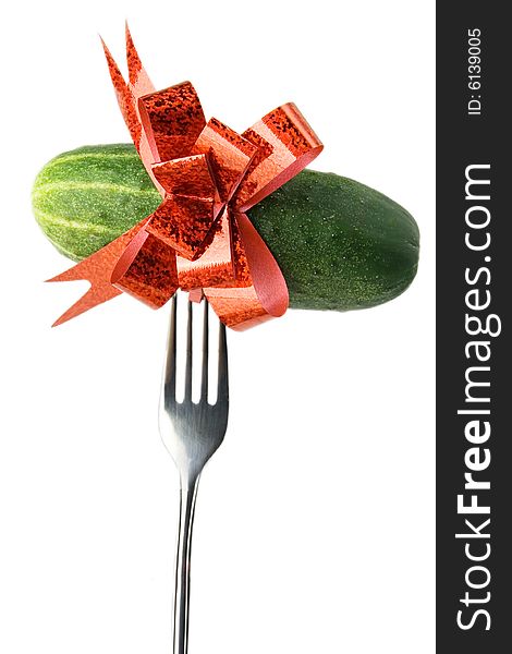 Green fresh cucumber bound with red bow stabbed on a fork. Green fresh cucumber bound with red bow stabbed on a fork