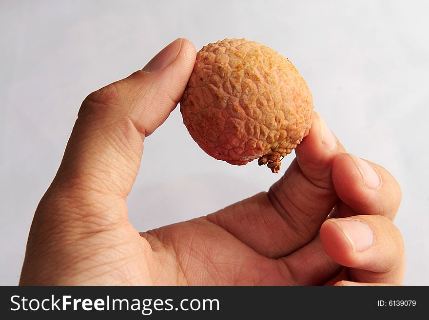 Ripe letchis in a man's hand