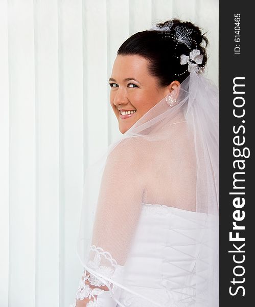 Pretty bride standing by the window