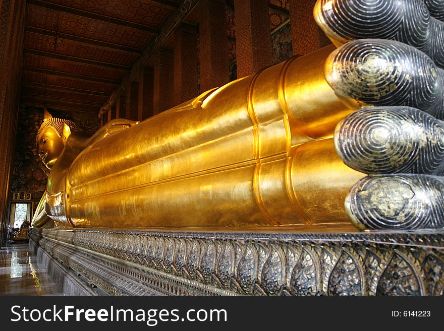 A recline gold buddha in a kings palace