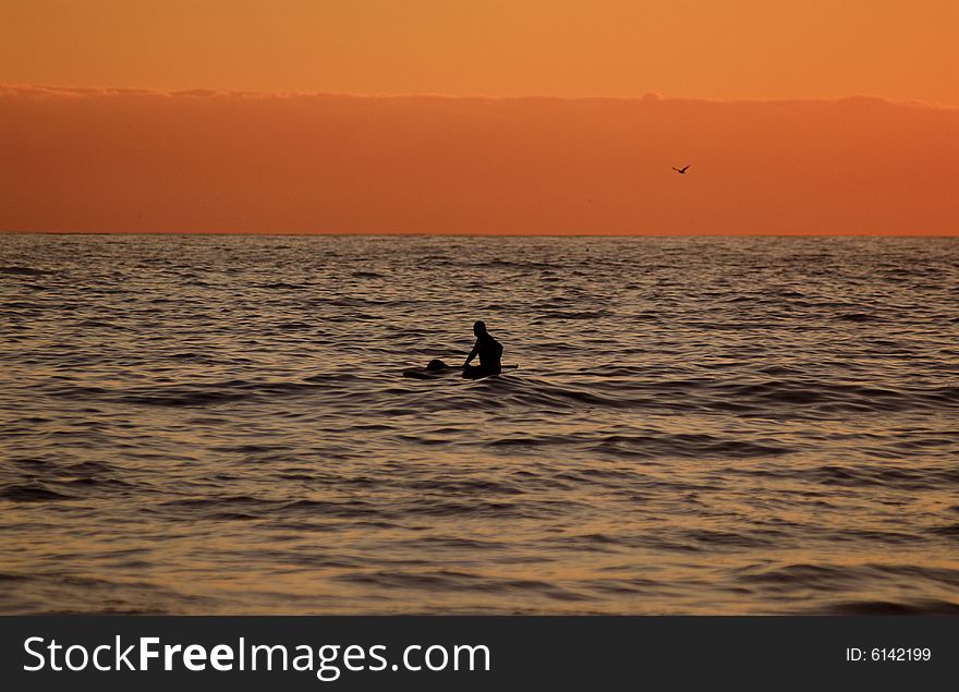 A lone paddler off the beach at Camps bay in Cape Town