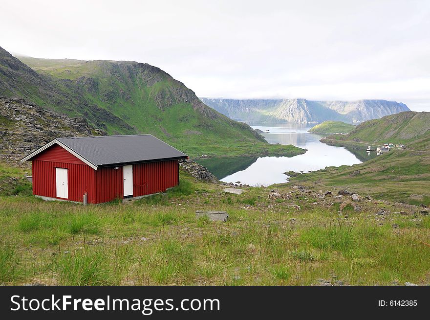 Red wooden cabin in northern Norway. Mountain scenery.