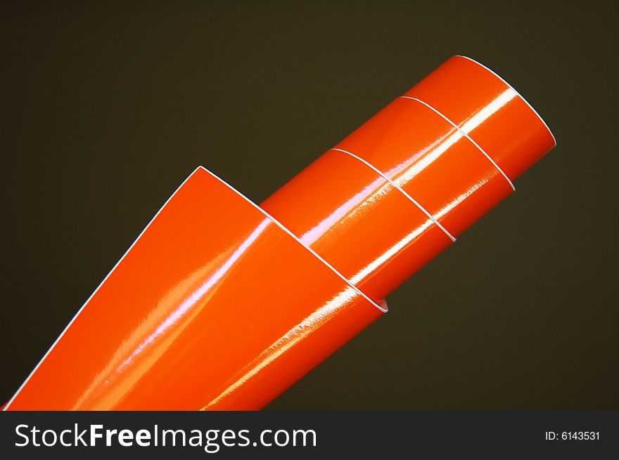 Orange shiny decorating foil over dark background