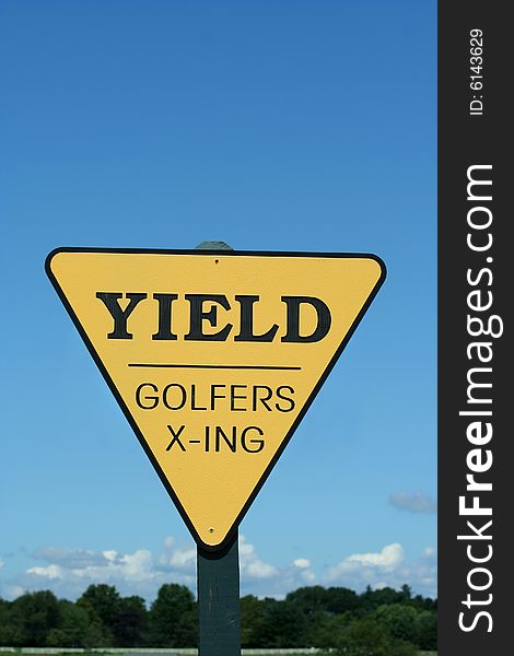 A yellow Yield golfer crossing sign