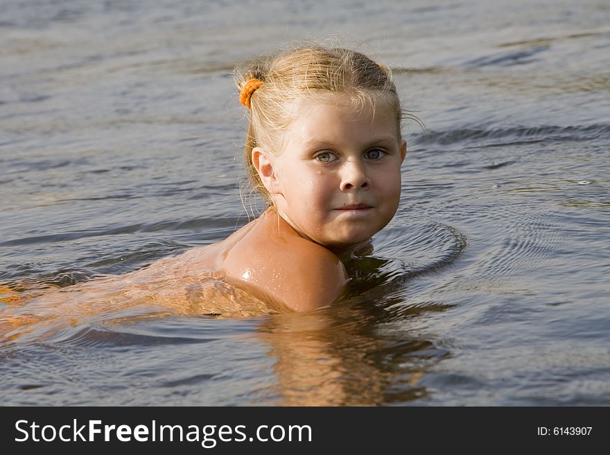 Little girl swimming in a river in the summer. Little girl swimming in a river in the summer