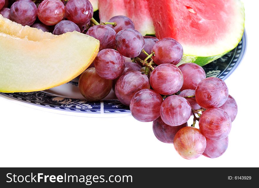 Variety of fresh colorful fruits in plate on background