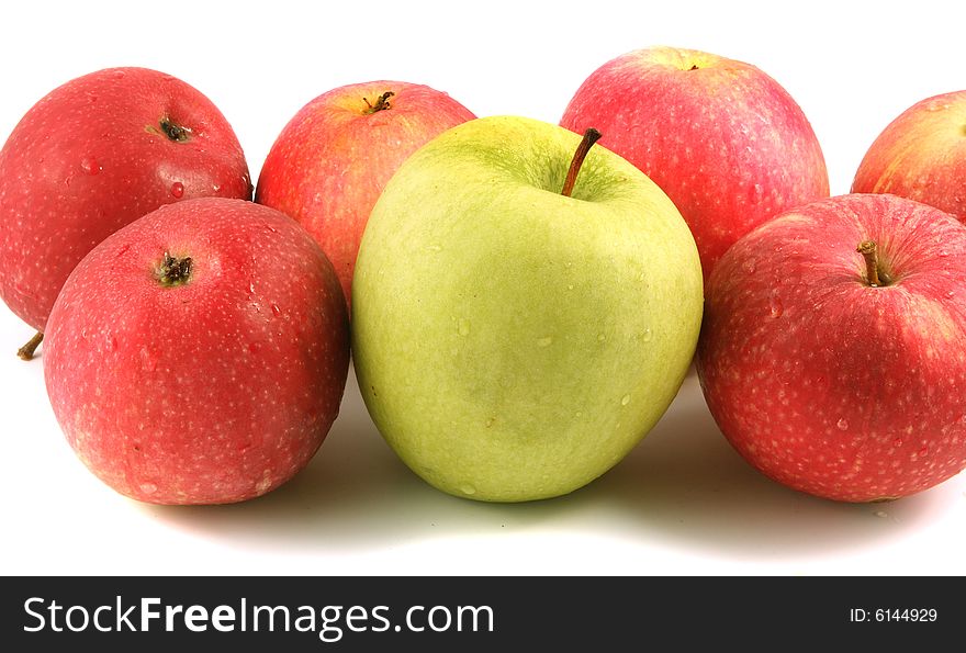 A lot of red and one green apple on a light background. A lot of red and one green apple on a light background