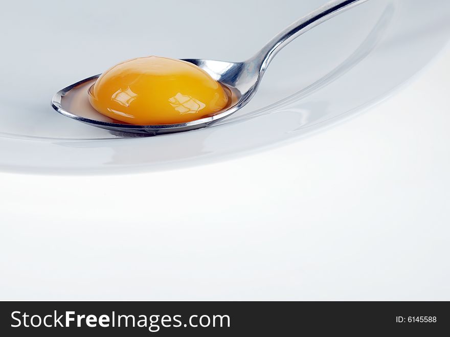 Broken egg on spoon, beauty of yellow. Broken egg on spoon, beauty of yellow