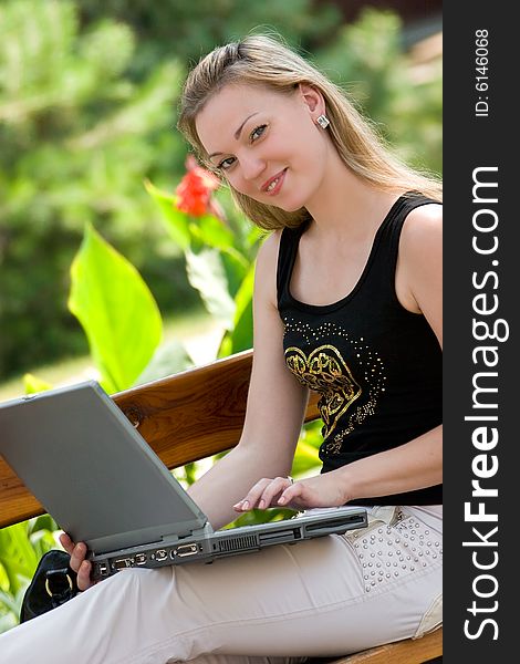 Happy young woman with laptop outdoors shot