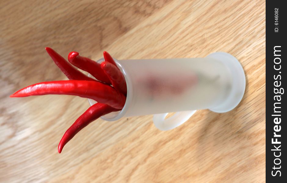 Red peppers in a frosted glass on wood table