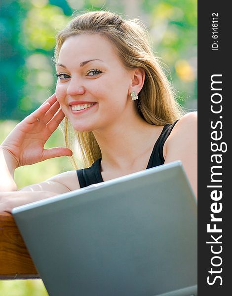 Happy young woman with laptop outdoors shot