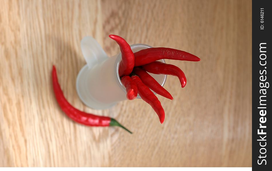 Red peppers in a frosted glass on wood table