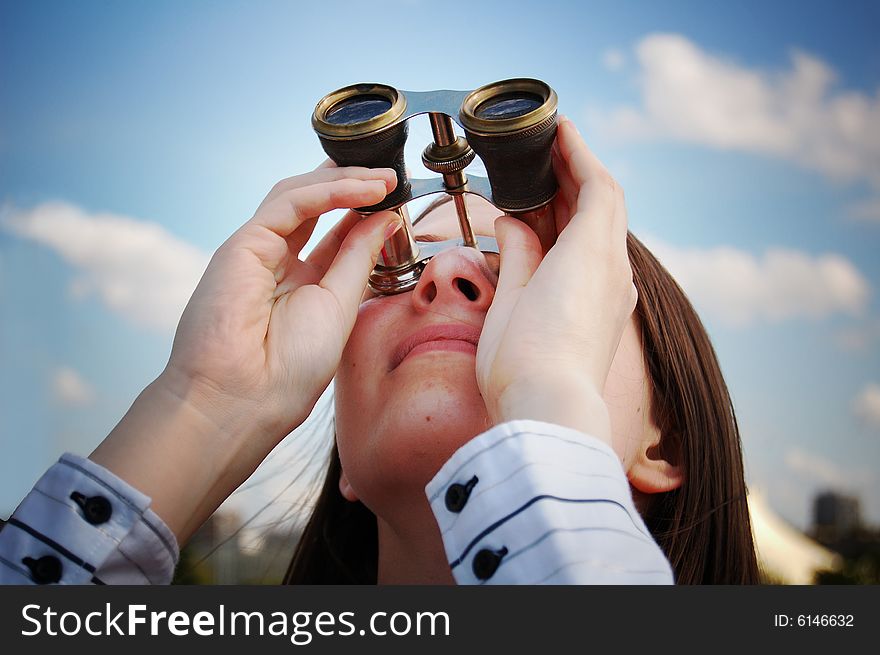 Girl with binocular against cloudy sky