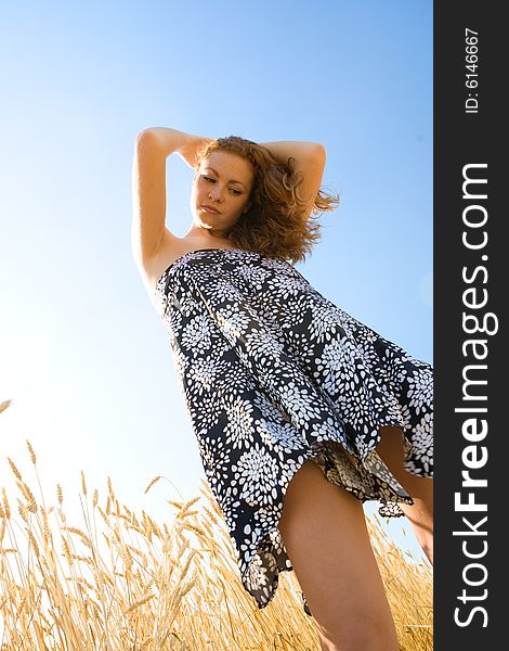 Red-haired young woman in wheat field