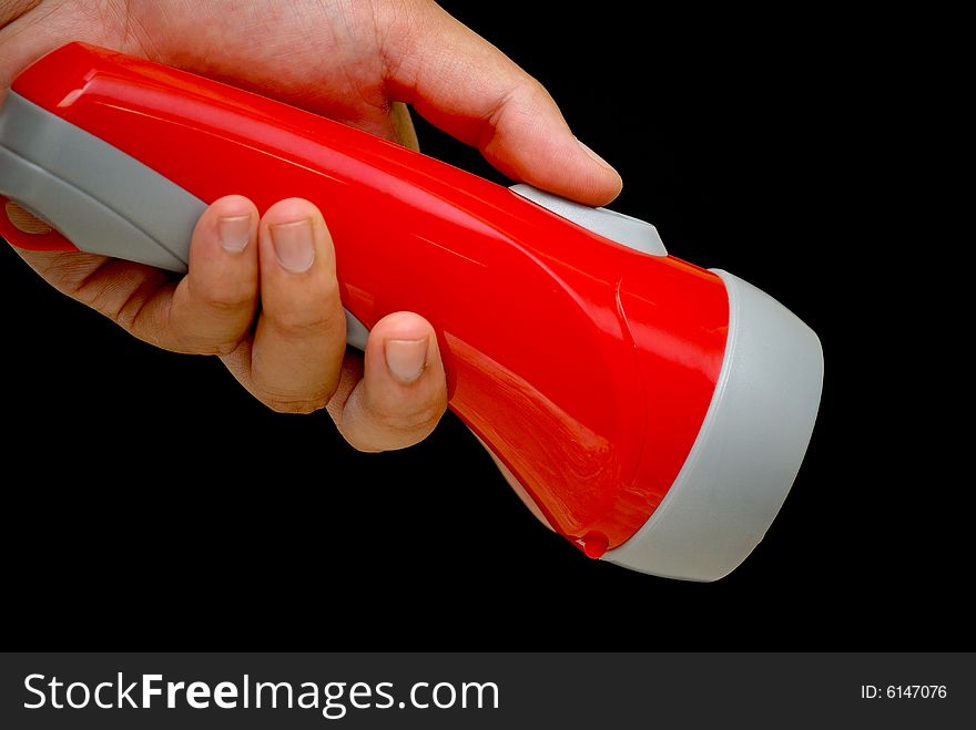 A hand holding a flash light trying to turn it on