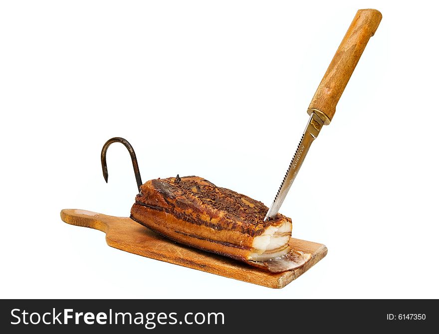 Smoked pork bacon on the wood tablet with knife and hook, domestic production. Smoked pork bacon on the wood tablet with knife and hook, domestic production