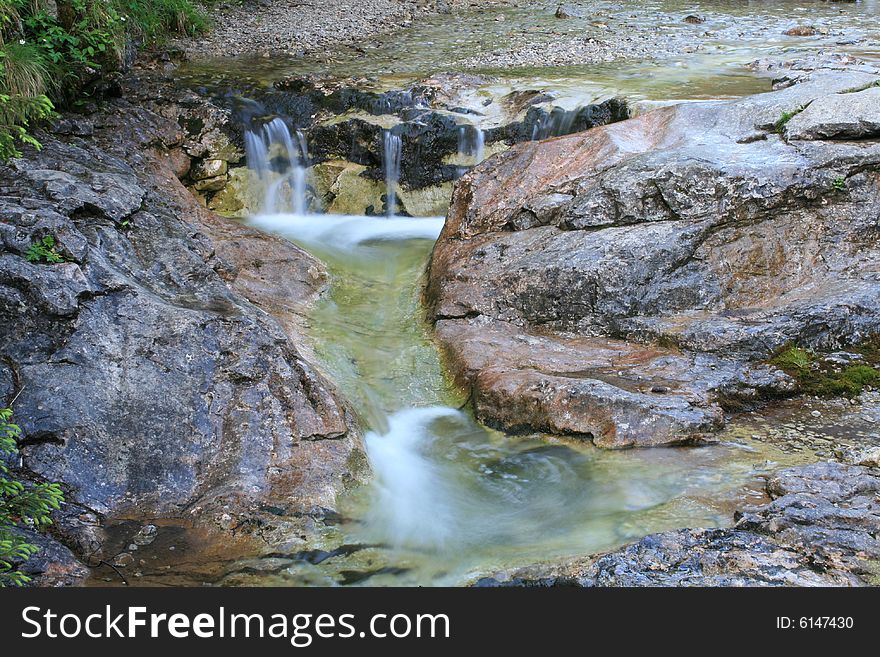 Mountain stream with small waterfall in long time exposure