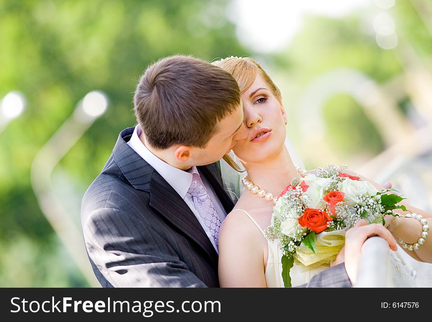 Colorful wedding shot of bride and groom kissing. Colorful wedding shot of bride and groom kissing