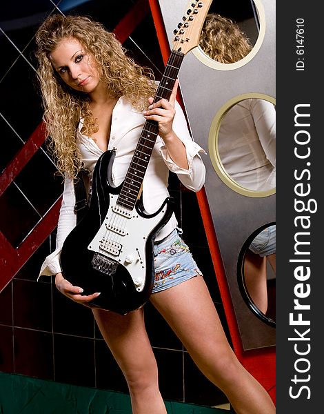 Beautiful girl in night club with electrical guitar
