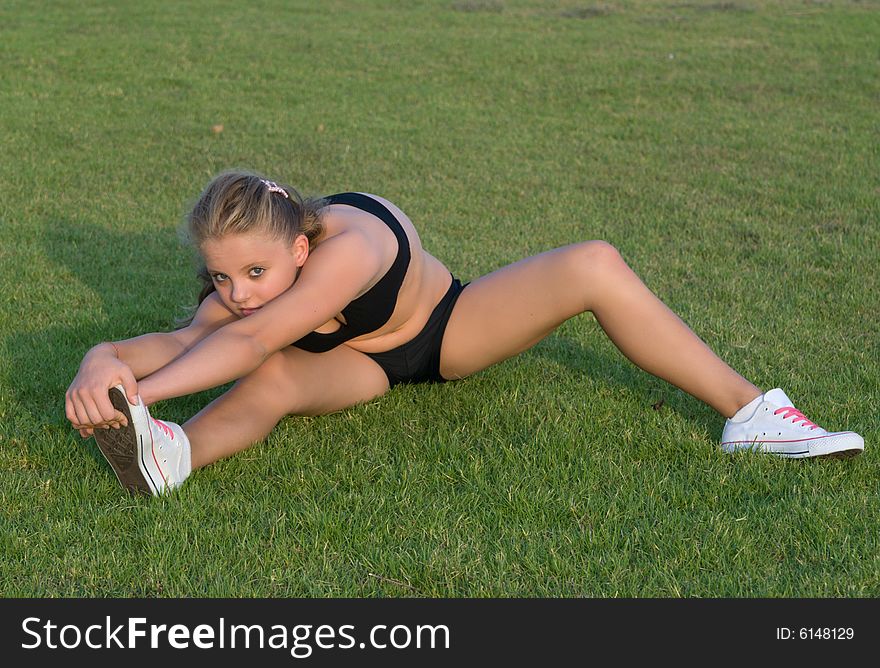 Young girl stretching her leg.