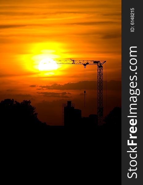 Sunset with a silhouette of a crane and factory. Sunset with a silhouette of a crane and factory